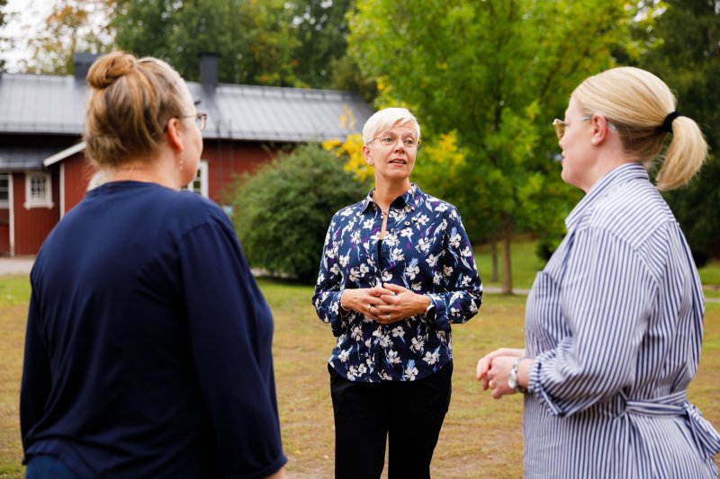 Ordförande Inger Damlin pratar med lärare på skolgård.